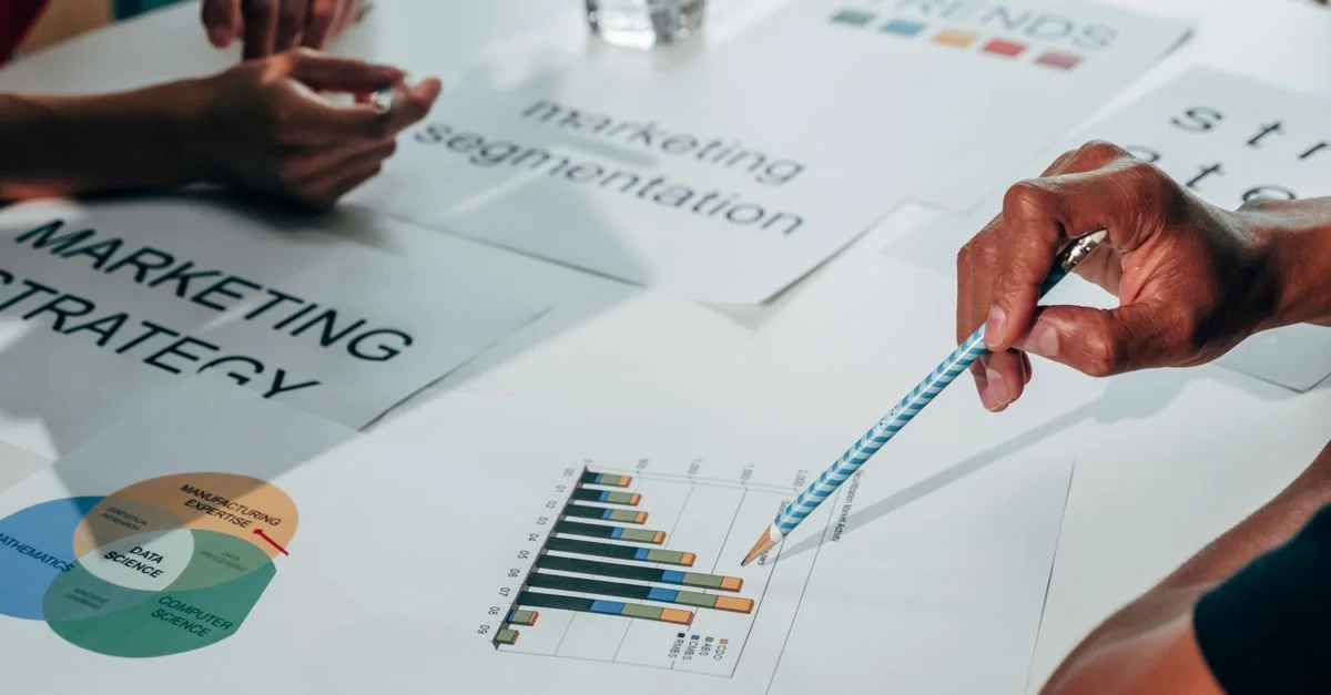 Équipe travaillant sur une stratégie marketing à l'aide de graphiques de données et de documents lors d'une réunion de bureau.