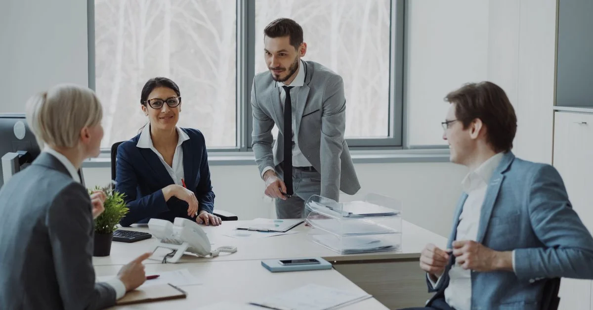 Groupe de professionnels dans un environnement de bureau moderne discutant des stratégies commerciales.