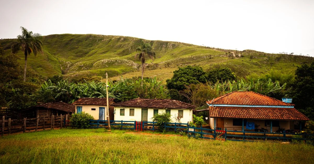 Une maison rurale rustique entourée de collines verdoyantes et d'une végétation tropicale luxuriante, idéale pour les amoureux de la nature.